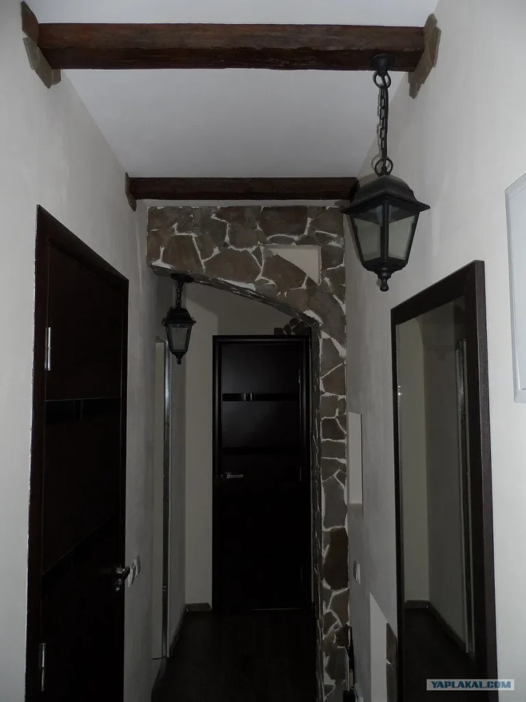 Rustic timber beams mounted on a white ceiling in a loft-style room.