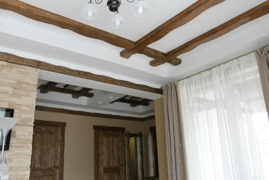 Industrial room design with exposed I-beams on a concrete ceiling.