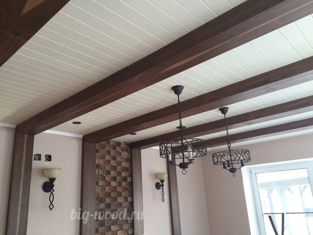 Spacious foyer featuring dark wood ceiling beams and stone accents.