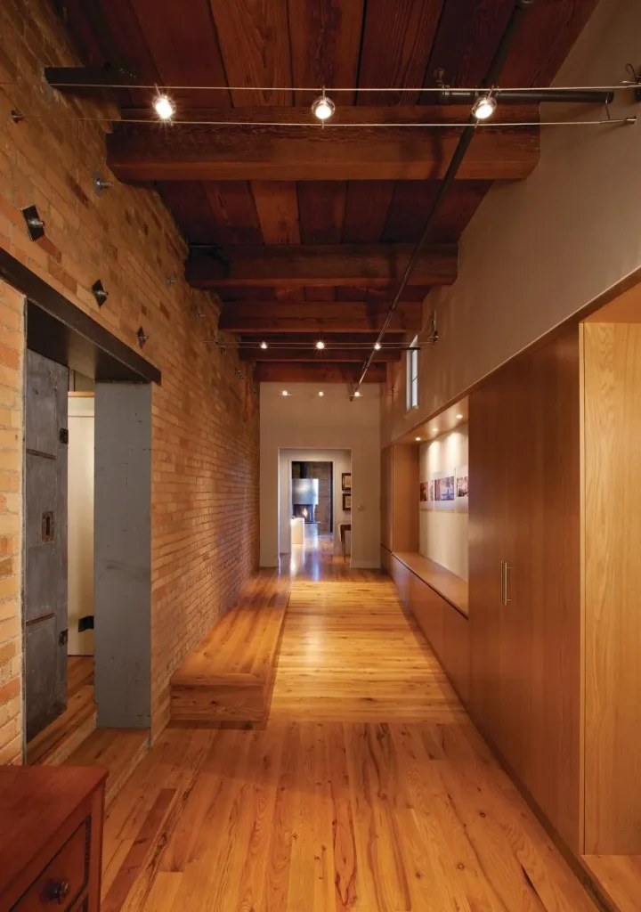 Spacious room with exposed timber beams and brick accent walls.