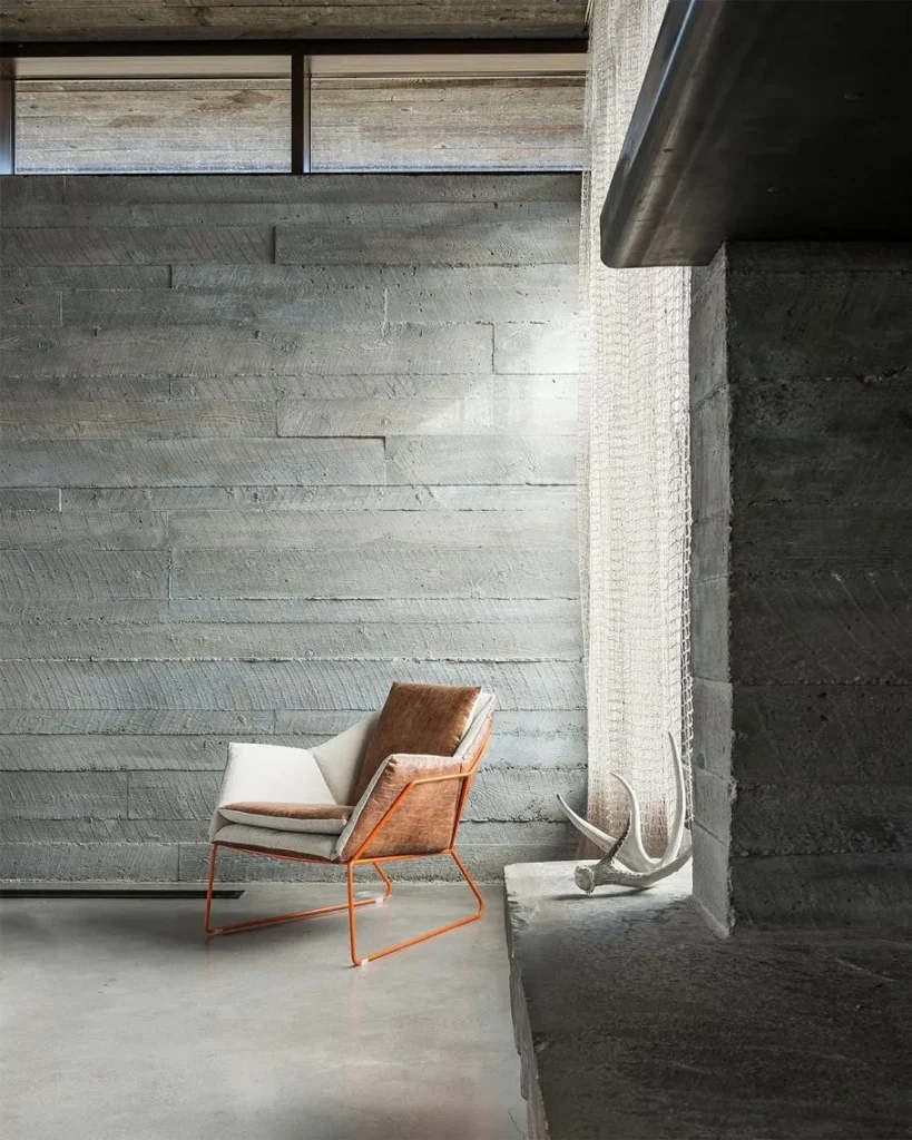 Seating area in a loft apartment set against an exposed concrete wall.