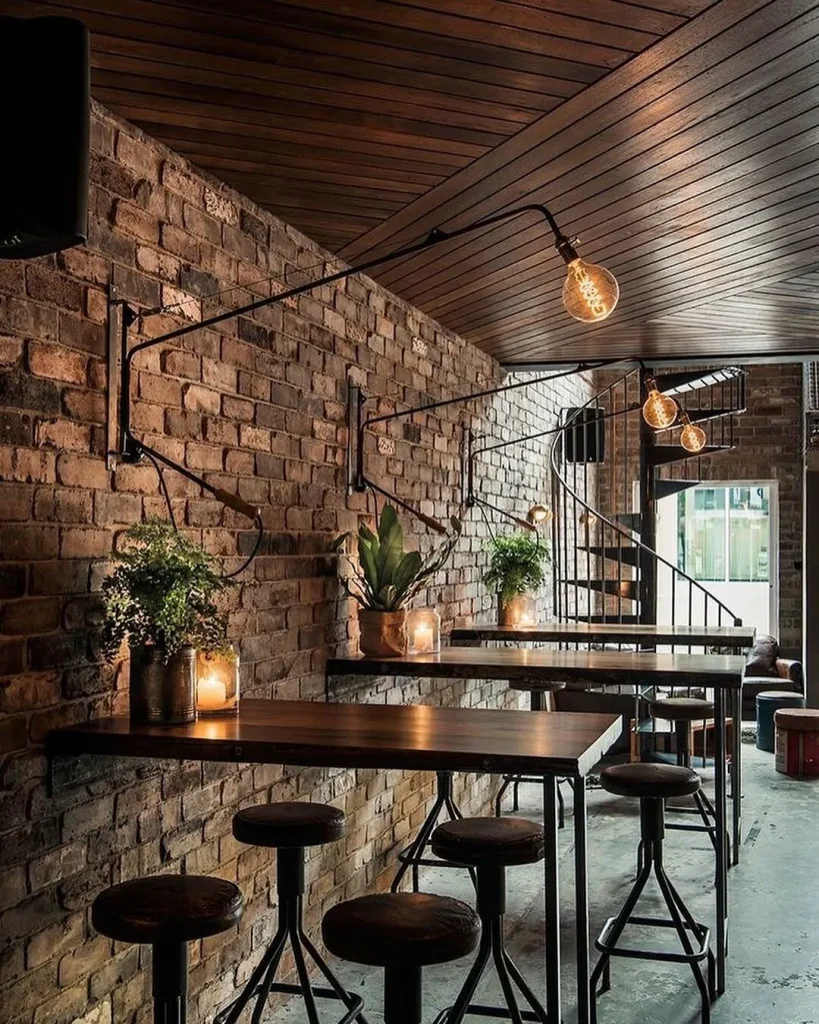 Loft-style cafe seating area set against a textured grey concrete wall.