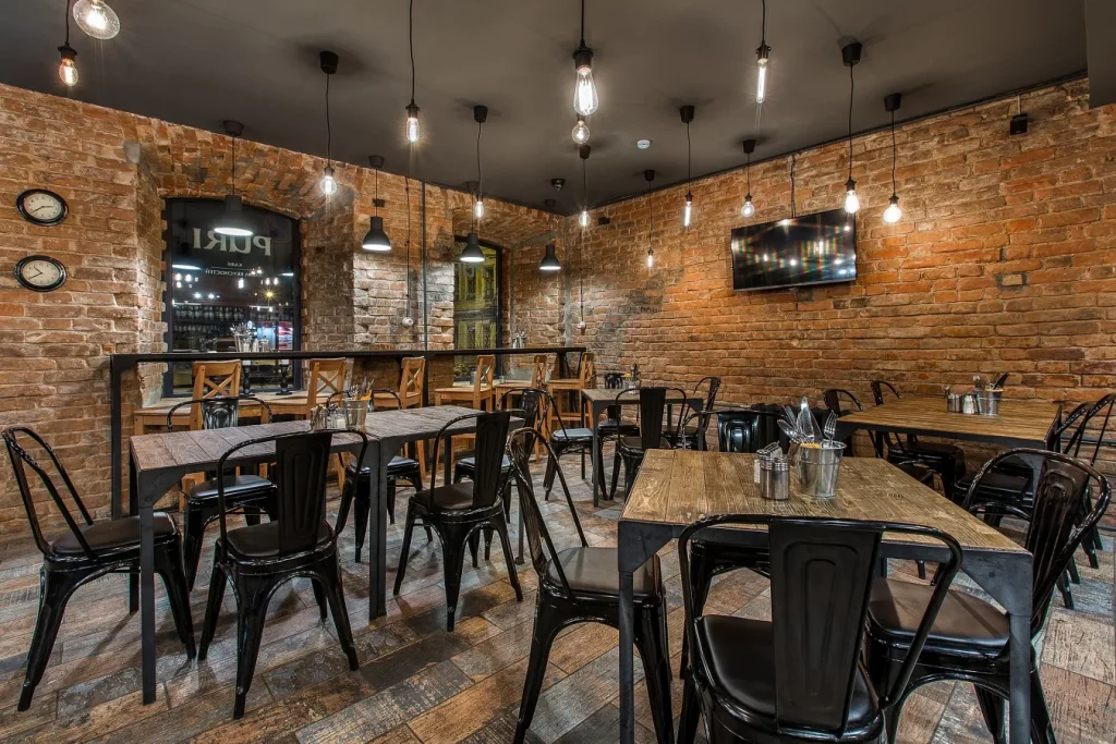 Industrial style cafe interior with track lighting and open pipework.