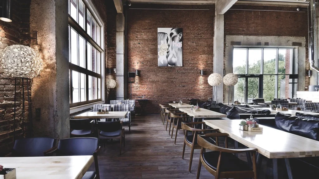 Industrial coffee shop layout with dark walls and soft pendant lighting.