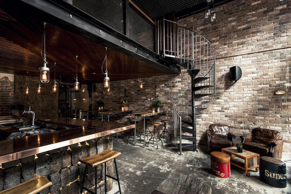 Cafe interior design with exposed metal piping and Edison bulb chandeliers.