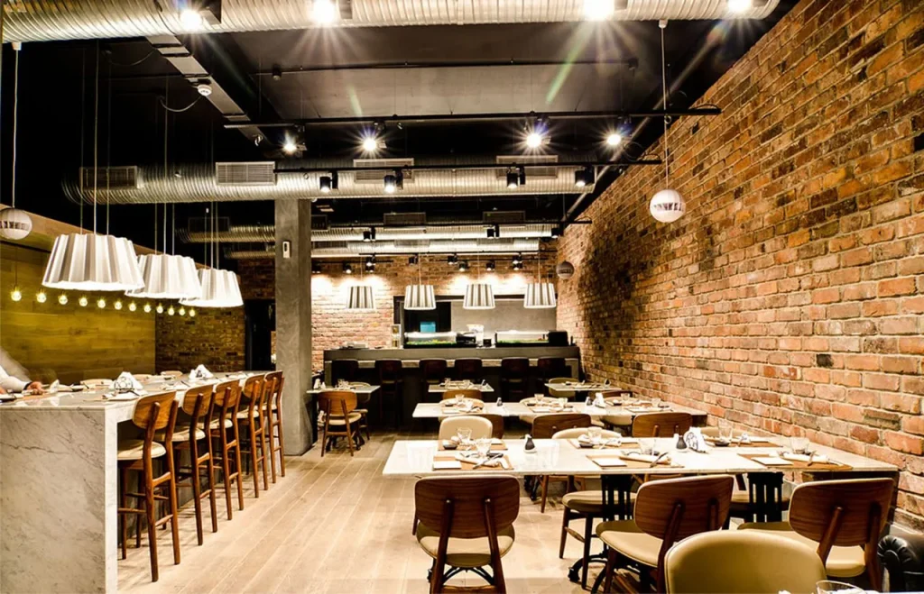 Loft-style dining hall in a cafe with concrete finishes and warm lights.