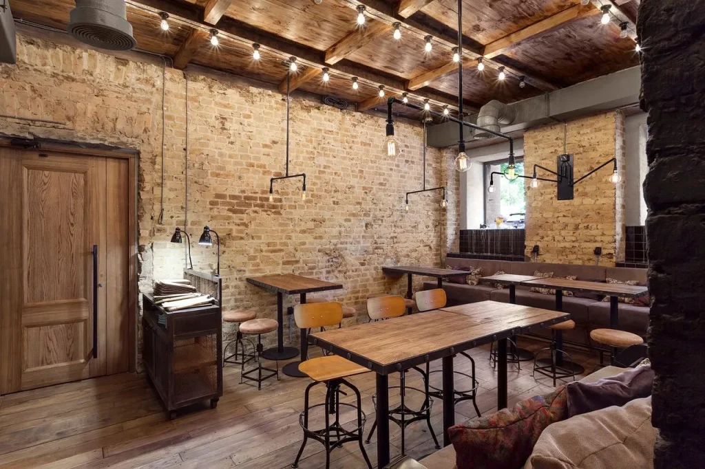 Small coffee shop layout with a dark metal service counter and bar stools.