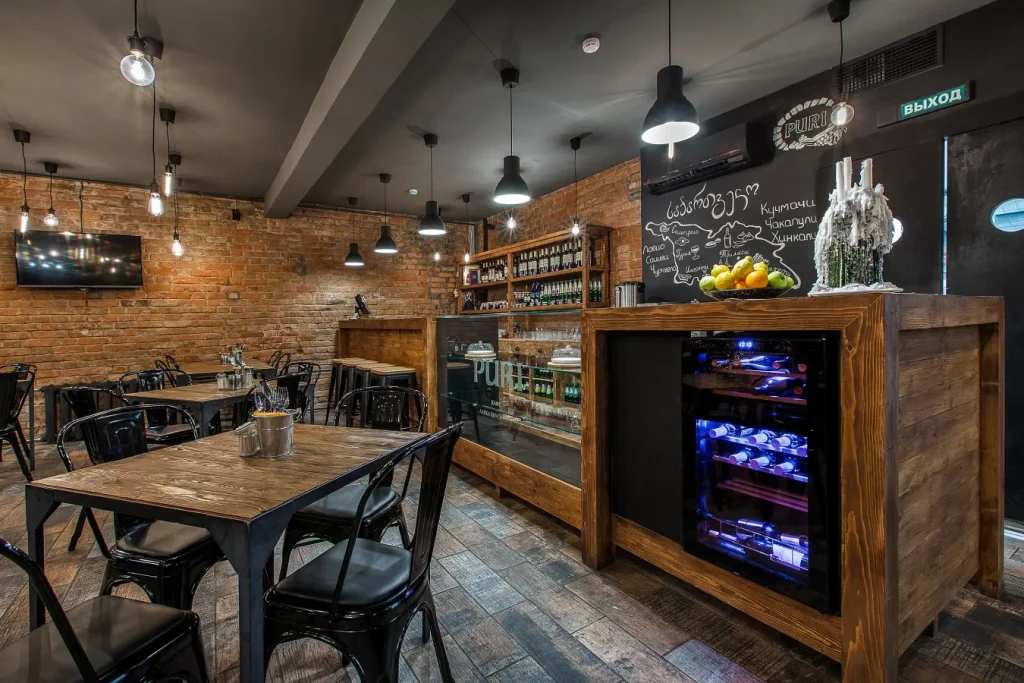 Industrial cafe space with a large chalkboard menu and wooden counters.