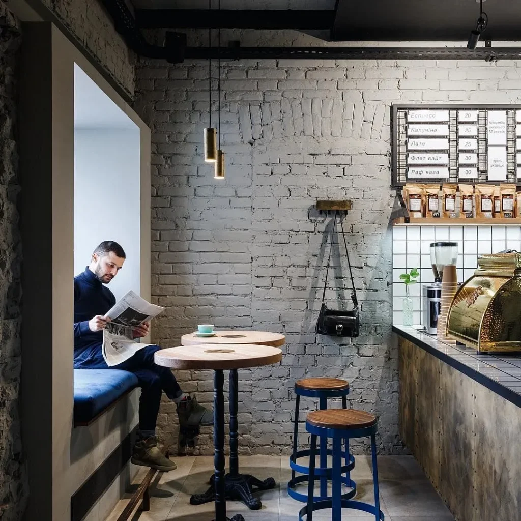 Cozy cafe corner with an exposed brick wall and warm overhead lights.