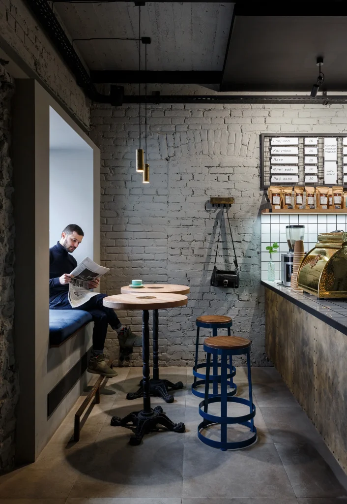 Cafe seating arrangement with metal frame chairs and small round tables.