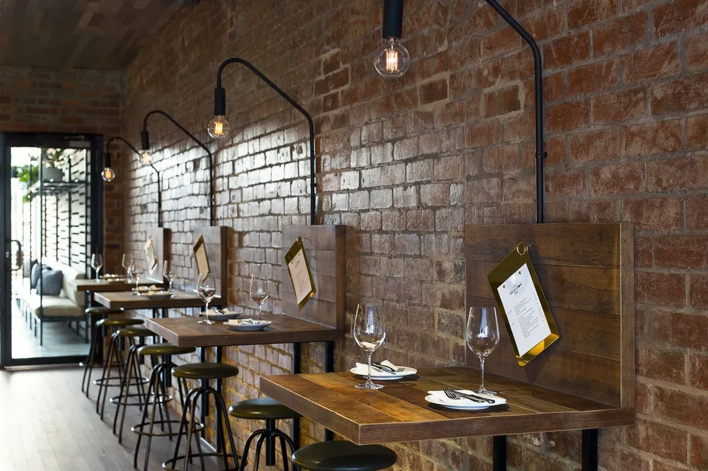 Bright loft cafe space with tall industrial windows and natural light.