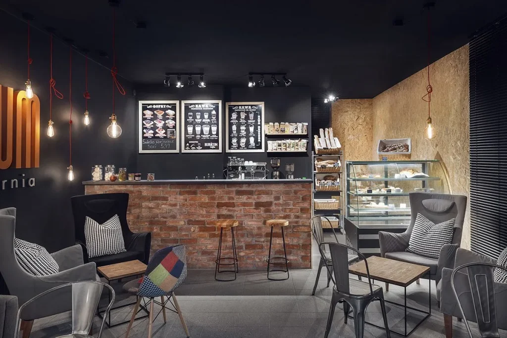 Loft-style dining hall in a cafe with concrete finishes and warm lights.